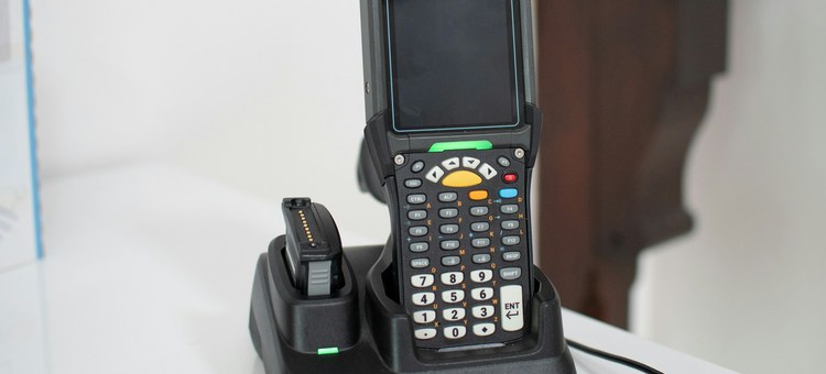 Handheld barcode scanner resting in its charging dock
